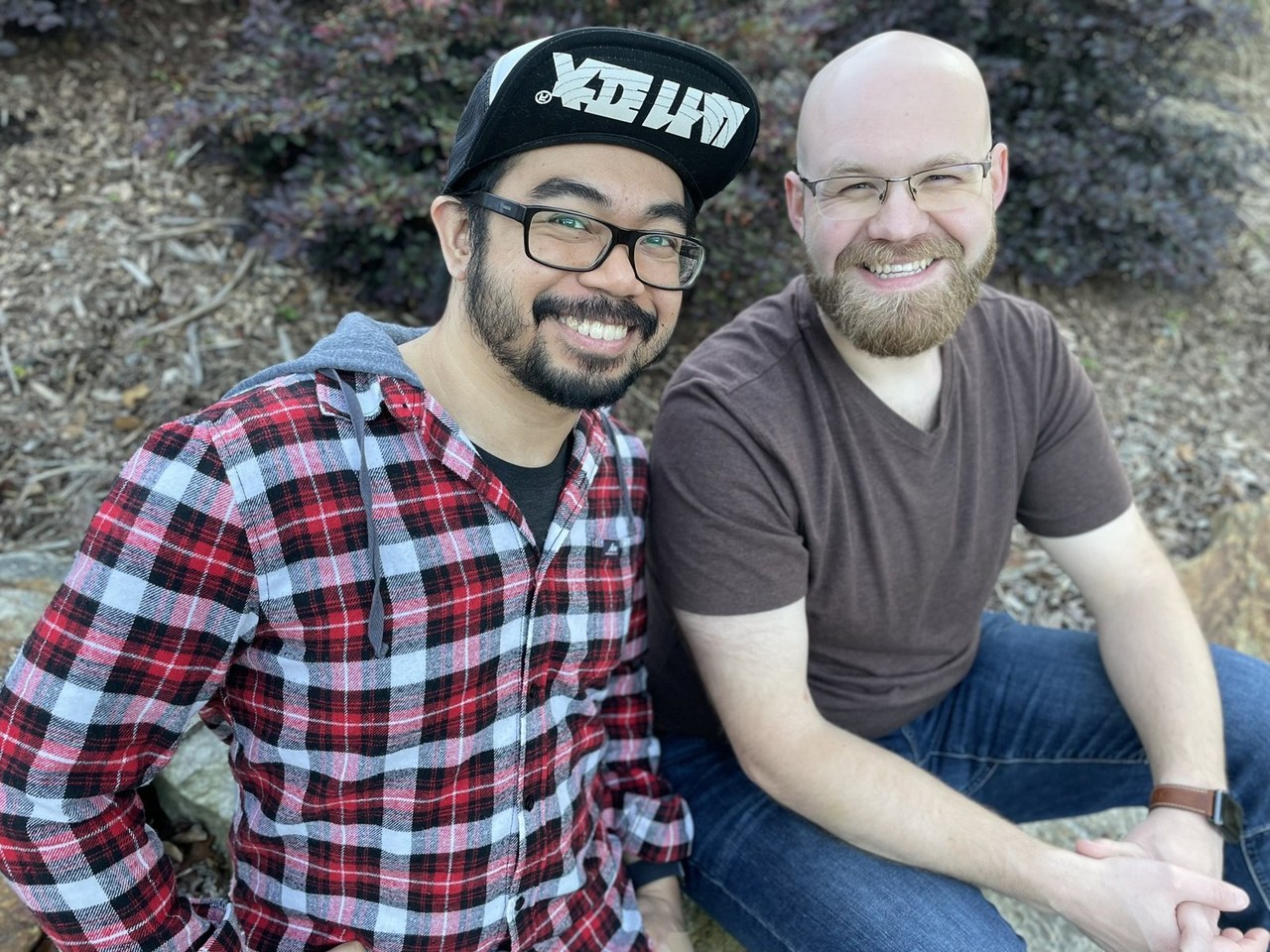 Omni and Phil of Drizzle Games, smiling outdoors